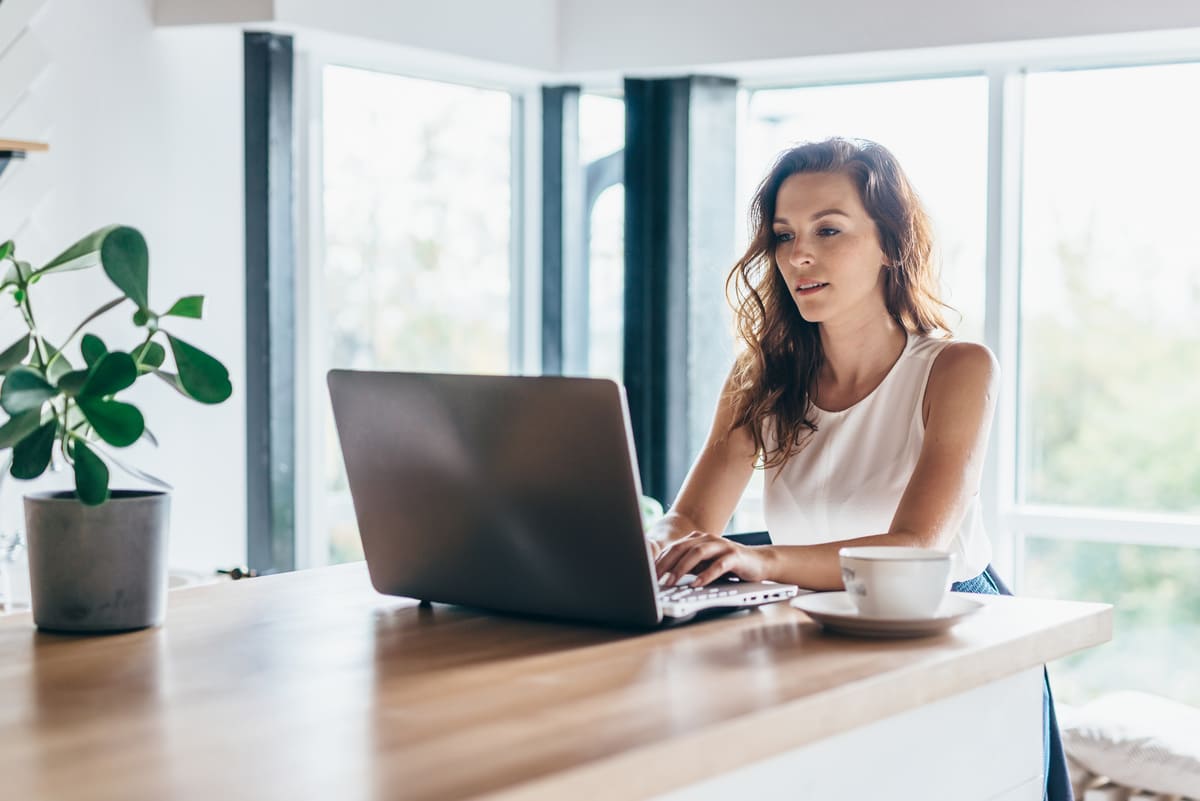 Personne travaillant sur un ordinateur portable depuis son domicile, illustrant les métiers en télétravail