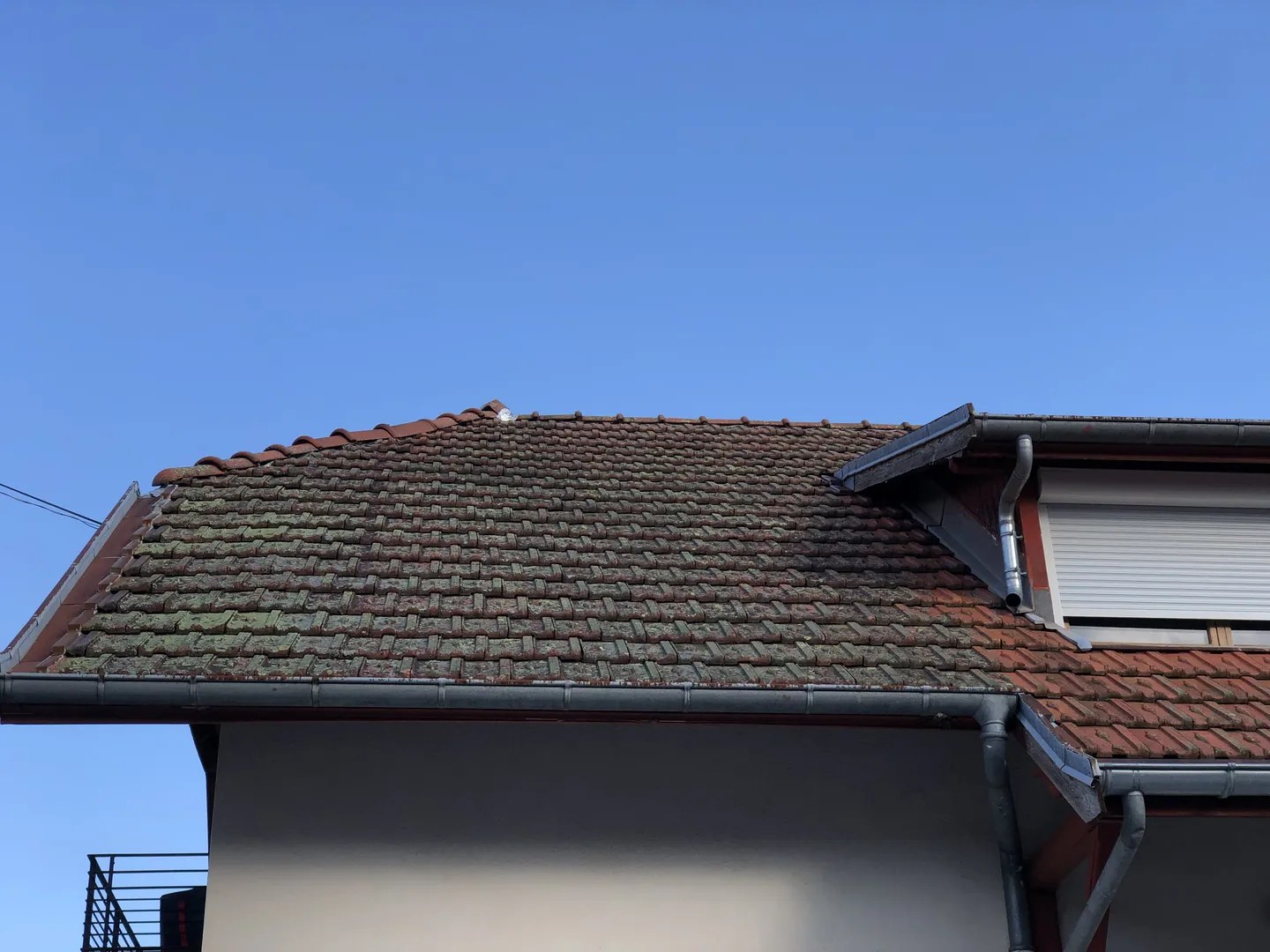Nettoyage d'un toit en tuiles recouvert de mousse par un professionnel